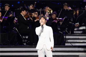 胡海泉与身后的交响乐团默契搭配,深情演唱经典歌曲《朋友》